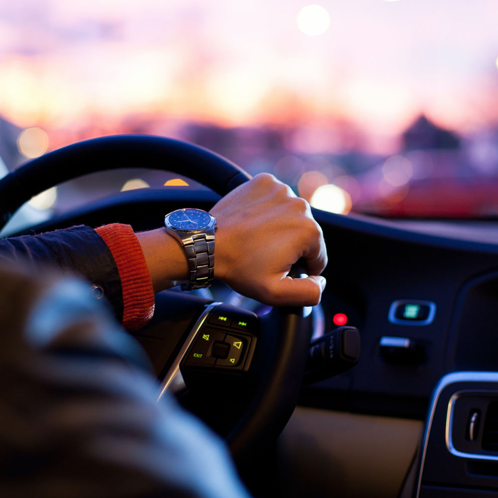 En man kör en bil från vår trafikskola Uppsala Trafikskola